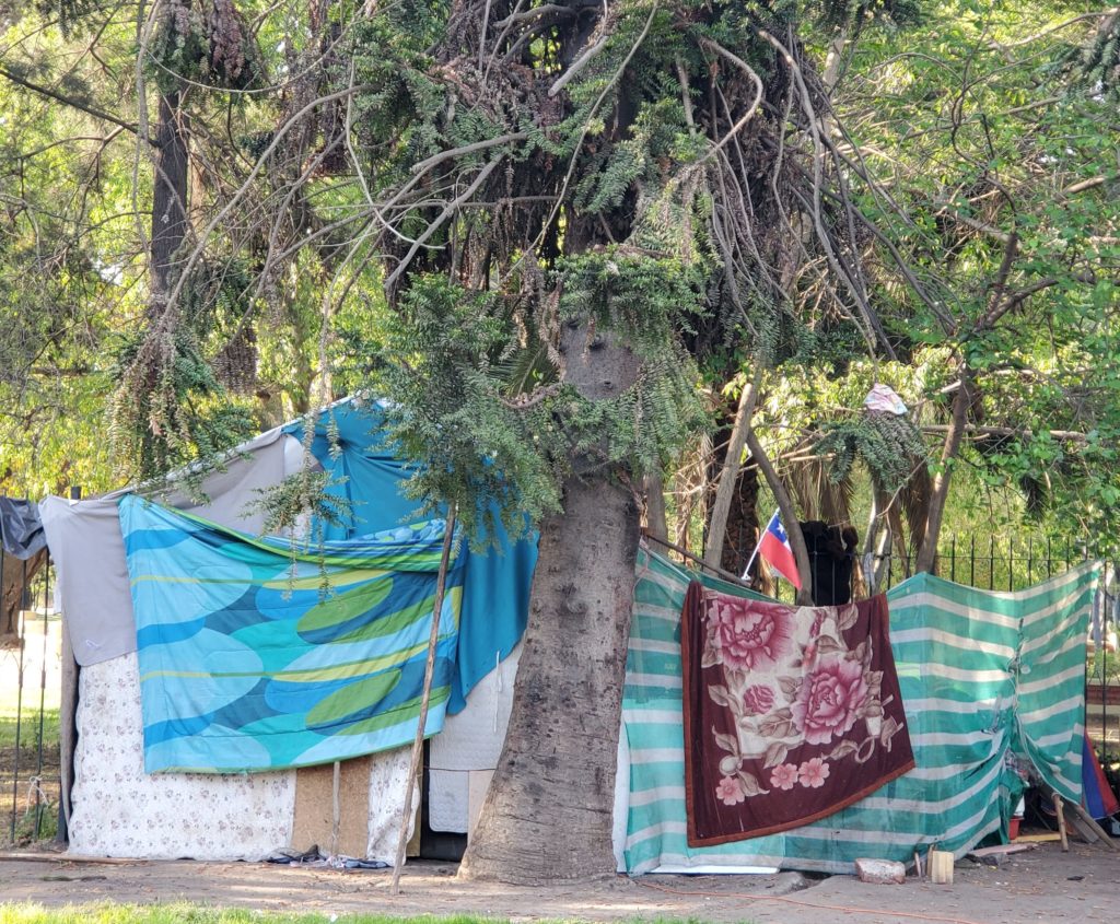 Homeless encampment against park wall