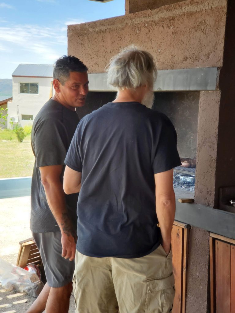 Alberto and John discussing asado, Los Reartes, Argentina